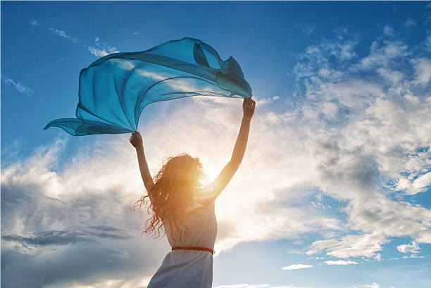 Woman holding a thin material to the sky